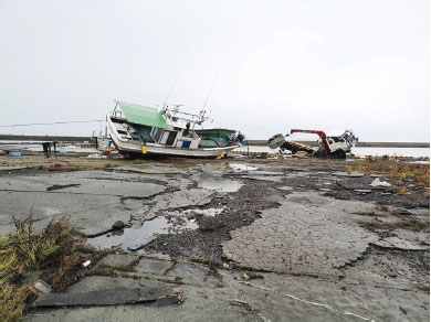 地震により岸壁が損傷し、津波により漁船が乗り上げた様子