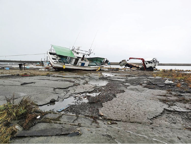 地震により岸壁が損傷し、津波により漁船が乗り上げた様子（鵜飼（うかい）漁港）
