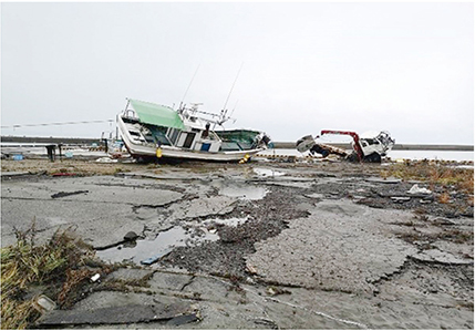 地震により岸壁が損傷し、津波により漁船が乗り上げた様子(鵜飼漁港)
